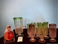 Full view of crackle glass pitcher, nine goblets and wooden candleholder