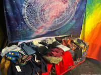 Overview of folded clothing, hats, two wall tapestries