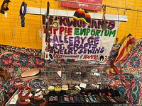 Overall view of jewelry display, embroidered pouches, woven straps and sign