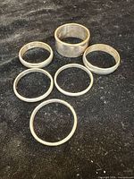 All seven sterling silver rings displayed on black fabric