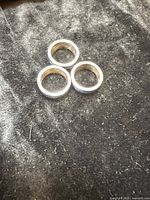 Three sterling silver rings on fabric background