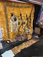 Display example tapestry, dream catcher, disco ball, packaged tapestries, bandanas visible