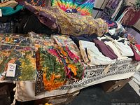 overview of table with tie-dye shorts, folded skirts/dress and other garments