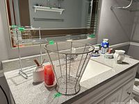 Overview on vanity: wire basket, towel stand, blue daisy ceramics, candle, diffuser bottle, tealight holder