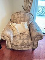 Front view of patterned upholstered armchair with ruffle pillow