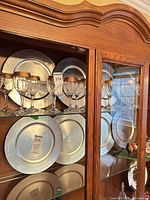 Plates displayed on two shelves inside cabinet