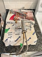 Faucet assembly with attached supply hoses, Delta box and additional packaging visible