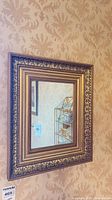 Gold ornate framed mirror on wall