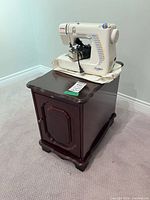 Sewing machine on top of wood cabinet