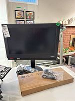 Front view of Lenovo ThinkCentre monitor with accessories in front