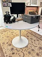 Full view of white tulip dining table with items placed on top (not included)