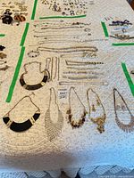 Overview of necklaces and bracelets laid on quilted surface