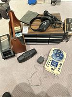 Group shot of all items including portable CD clock radio, headphones, cassette player, storage units, tapes, AC adapter