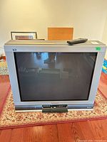 Front view of Panasonic 32" CRT TV with remote on top