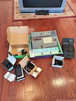 Lot overview showing project lab board, phones in boxes, tool kit, cords