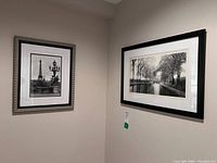 Both framed prints hung on wall