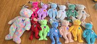 Group image of 13 Ty Birthday Bear plush toys on table