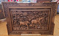 Front view of carved wood panel showing entire elephant scene and frame