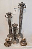 Group shot of three tall ornate metal candlesticks and two short Rogers sterling holders