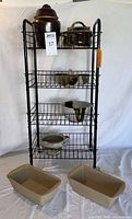 Full view of rolling rack with crockery items displayed and loaf pans on floor