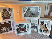 Six Dept 56 North Pole Series buildings in original Styrofoam packaging on shelf