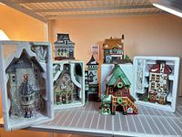 All seven Department 56 buildings, two in Styrofoam, displayed on shelf