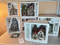 Six Department 56 buildings in Styrofoam liners on shelf