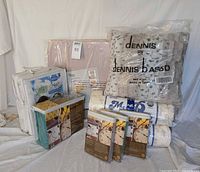 Full lot showing MyPillow rolls, Dennis Basso faux fur pillow, mattress protector, pillowcase sets, storage containers and sheet sets