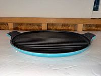 Top view of round blue enameled cast iron ridged grill pan with handles