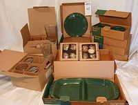 Boxed dinner plates, dessert bowls, tumblers, napkin rings, divided dish displayed