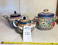 Front view showing both teapots and lidded urn with measuring tape