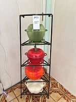 full view of four Dutch ovens stacked on black corner stand
