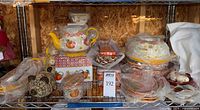 Overall shelf view showing majority of pieces including teapot, various bakers, jar, plates