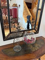 Both candle holders on tabletop in front of mirror