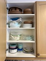 Full cabinet view showing all dinnerware, bakeware and storage pieces in situ