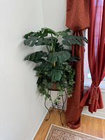 Full view of artificial plant on stand in corner