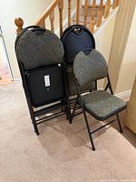 Front view of six folded chairs with one open to show seat and back