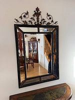 Full view of mirror showing frame, crest, and reflection