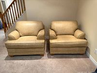 Front view of both tan leather armchairs