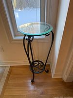 Full view of plant stand showing glass top and metal frame