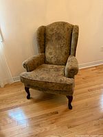 Front left view of floral wingback chair showing upholstery and cabriole legs