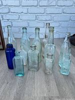 All 12 glass bottles grouped on floor