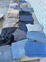 Full view of many folded men’s pants lined on surface