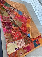 Full view of beaded patchwork throw blanket showing size, colours and backing