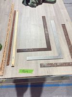 Overview of three yardsticks and three framing squares on tabletop