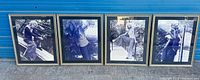 All four framed photographs lined up in front of blue wall