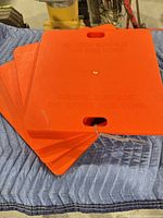 Stacked orange utility pads showing size and color