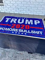 Full view of blue TRUMP 2020 NO MORE BULLSHIT flag laid flat