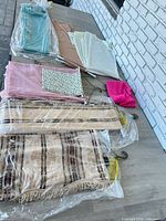 Assorted folded curtain panels and valances laid out on table