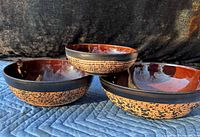 Three graduated ceramic bowls, exterior design and interior glaze visible